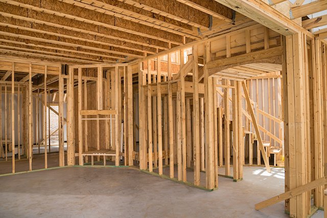 Framing, rough plumbing and wiring exposed before insulation and drywall